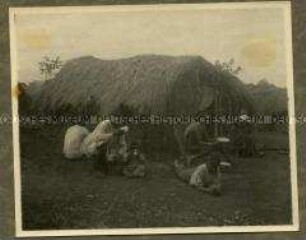 Afrikaner bei der Verpflegung vor einer provisorischen Hütte