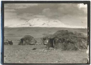 Strohhäuser der Aymara-Indianer im Dorf Sajama mit dem Quisiquisini im Hintergrund
