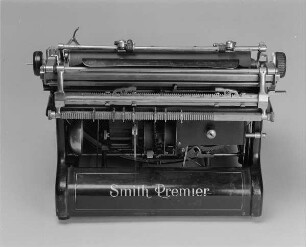 Typenhebelschreibmaschine "Smith Premier" (Modell 10). Vorderanschlag (sofort sichtbare Schrift), Volltastatur mit 84 Tasten, Farbband (Rollen hinten). Rückansicht : Typenhebelschreibmaschine "Smith Premier" (Modell 10). Vorderanschlag (sofort sichtbare Schrift), Volltastatur mit 84 Tasten, Farbband (Rollen hinten). Rückansicht. Baujahr: ab 1908; Hersteller: Smith Premier Typewriter Co. Syracuse N. Y. Verwalter: Sächsische Landesbibliothek - Staats- und Universitätsbibliothek Dresden (SLUB), Stenografische Sammlung, Inventar-Nummer R i 0012