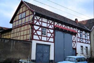 Gehöft mit großem Gebäude über dem Tor; Metalltor straßenseitig; Sichtfachwerk