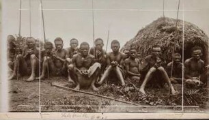 Gruppenportrait : Gruppenportrait mit 16 Männern vor einer Hütte sitzend