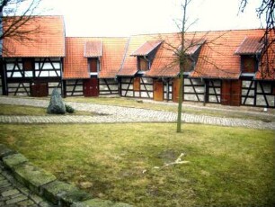 Evangelische Pfarrkirche - Kirchhof im Nordwesten mit (rekonstruierten) Gaden (Fachwerk auf steinernem Stock - Kirchhofmauer als Außenmauer) in Übersicht-260220120