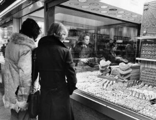 Schmuck hat Anziehungskraft. Frauen stehen vor den Auslagen eines Schmuckgeschäftes