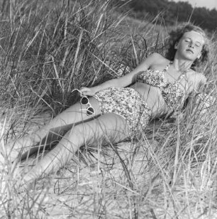 Frau im Bikini mit Sonnenbrille am Strand