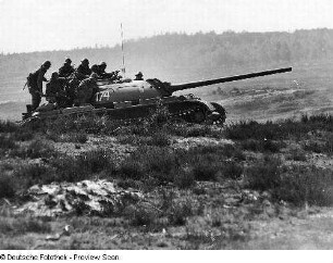 Deutschland . Nationale Volksarmee - Landstreitkräfte. Kampfpanzer mit aufgesessenen Schützen in Fahrt in offenem Gelände