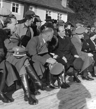 Zuschauer einer winterlichen Sportvorführung für Dr. Robert Ley (Reichsleiter der NSDAP und Leiter der Deutschen Arbeitsfront) und seinen Anhang nebst Frauen. Links ein hoher SA-Führer
