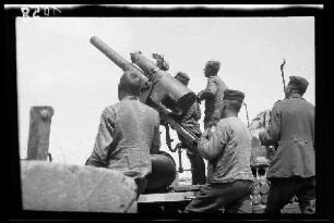 Zwischen Comines (=Comines-Warneton, Belgien) und Messines (=Mesen, Belgien): Soldaten an einer "Feuerstellung der Flakbatterie Bragard (Flak auf Kraftwagen)" beim Ausrichten (Rückansicht, Nahaufnahme)
