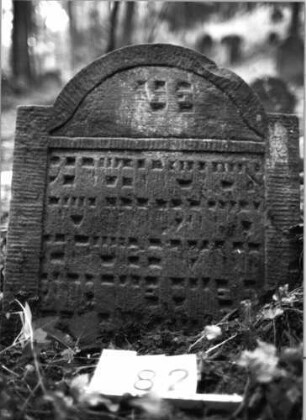Grabstein 182 (Index: 99803231) Material: Sandstein Zustand: eingesunken, Textverlust Maße HxBxT: 52x57x10 cm Beschreibung: Stel emit eingezogenem Rundbogen und profiliertem Rand: Grabstein 182