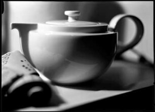 Stillleben mit Teekanne und Filmrolle