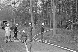 Großübung: Klein Wesenberg: Wäldchen am Schützenhaus: Feuerwehrmänner auf Waldweg verlegen Feuerwehrschläuche: im Hintergrund links Einsatzfahrzeug
