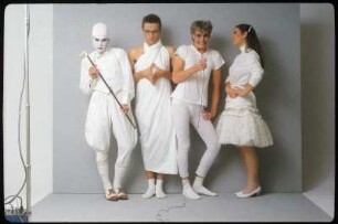 Fotoshooting einer Performance- oder Schauspielgruppe : Ingolf Thiel mit drei weiteren Schauspielern in weißen Kostümen vor einem grauen Hintergrund