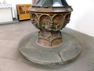 Stiftskirche-Langhaus Innen - Taufbecken (Gotisch) mit Ornamentik und halbplastischen Figuren in Farbigkeit-Detailansicht 01