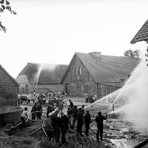 Gut Altfresenburg: Brand des Bullenstall: vorne Löscharbeiten, dahinter werden benachbarte Gutsgebäude unter Wasser gesetzt