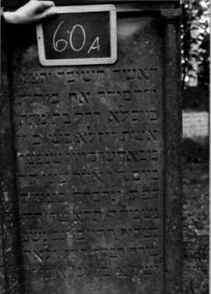 Grabstein 60 (Index: 100111126) Material: Sandstein Zustand: leicht verwittert Maße HxBxT: 180x63x17 cm Beschreibung: ädikulaartige Stele mit Säulen, Giebel Symbolik: Blüte: Grabstein 60A