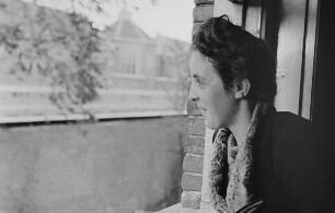 Zweiter Weltkrieg. Niederlande unter deutscher Besatzung. Junge Frau in Profilansicht an einem Fenster (wohl bei Den Haag)