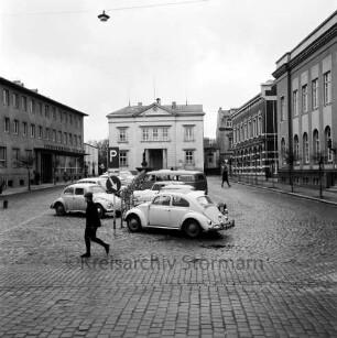 Markt: vorne parkende Pkws, rechts das Stadthaus, links die Kreissparkasse Stormarn, mittig im Hintergrund das Rathaus: Blick von Süden