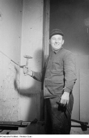Porträt eines Arbeiters mit Hammer und Meißel auf der Baustelle Doktor-Hermann-Duncker-Straße