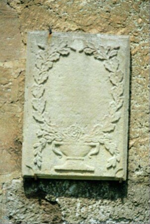 Grabplatte an der Kirchenmauer