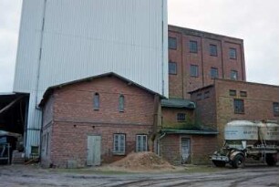 Lasbek-Barkhorst: Mühlenweg 3: Barkhorster Mühle W. F. Stoltenberg: Mühlengebäude aus Backstein: hinten links modernes Silo: vorne rechts Anhänger mit Kraftfutter-Tanks: 26. Januar 1999