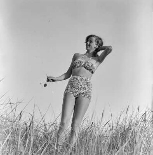 Frau im Bikini mit Sonnenbrille am Strand