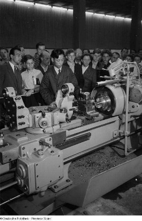 Besucher des chinesischen Pavillons der Leipziger Herbstmesse 1954 betrachten die Vorführung einer Industriemaschine