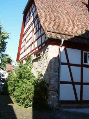 Kirchhof im Norden-Rest der Kirchhofmauer in nahezu Originalhöhe als Außenwand einer angebauten Scheune (Kirchhof im 18 Jh aufgelöst und Kirchhofmauer mit Wehrgang weitgehend abgetragen)