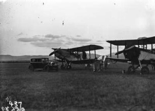 Flugplatz nahe der Stadt Malelane : Zwei Doppeldecker stehen auf einer als Flugplatz genutzten Wiese. Eine der beiden Maschinen wird gerade von einigen Personen inspiziert. Vor den Flugzeugen steht ein Auto.