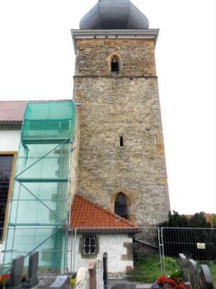 Evangelische Kirche - Kirchturm von Süden (gotisch gegründet) mit Schießscharte (Schlitzscharte) im Mittelgeschoß sowie Glockengeschoß mit Zwiebelhaube