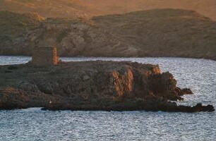 Spanien. Menorca. Cap Cavalleria. Alter Turm auf Felsen im Meer