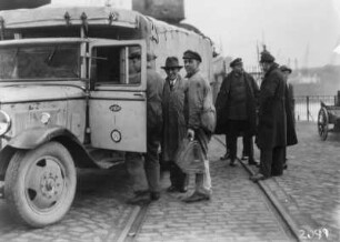 Männer vor einem Expeditionsfahrzeug : Eine Gruppe von Männern vor einem LKW der Expedition, wahrscheinlich am Hamburger Hafen.