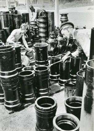 Hamburger Wasserwerke GmbH. Blick in das Rohrlager Sorbenstraße. Arbeiter tragen Korrosionsschutz auf