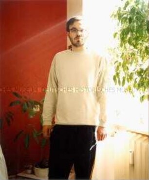 Mann mit Brille vor einem Fenster mit einem Ficus benjamini (Prämiertes Foto)