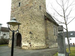 Ansicht von Nordosten mit Basis des Spätromanischen Chorturms (bis 1916 genutzt) sowie Langhaus (1916 nach Blitzschlag verändernd überarbeitet) im ehemaligen Kirchhof (als Begräbnisplatz aufgelassen)