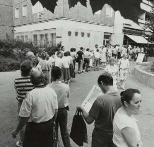 Dresden vor der Währungsumstellung im Juni 1990 : Warteschlange zum Geldumtausch vor der Zweigstelle der Stadtsparkasse Dresden, Neustädter Markt