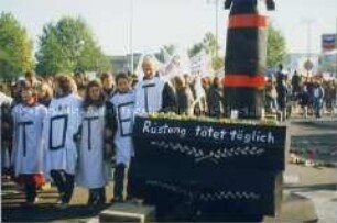 Demonstranten mit Transparent "Rüstung tötet täglich" und Rakete-Särge-Modell auf der Friedenskundgebung in Bonn am 22. Oktober 1983