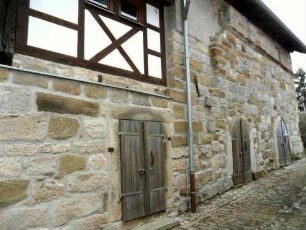 Evangelische Pfarrkirche - Ansicht im Westsüdwesten (von Ortsseite) im Bereich ehemaliges Torhaus mit Kirchhofmauer (Außenmauer des Torhauses) sowie einst aufsitzendem Wehrgang