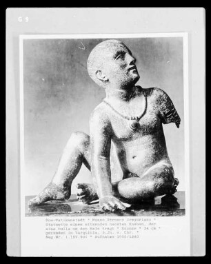 Statuette eines sitzenden nackten Knaben, der eine bulla um den Hals trägt