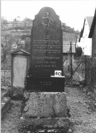 Grabstein 40 (Index: 99805051) Material: geschliffener Granit Zustand: gut Maße HxBxT: 195x160x23 cm Beschreibung: Stele auf gestuftem Sockel mit gestuft eingezogenem Rundbogen Symbolik: eingemeißelte Blüte im Rundbogen: Grabstein 40