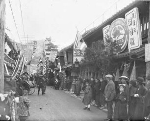 Nagasaki, Japan. Blick in eine belebte Geschäftsstraße mit Einheimischen und Touristen in Rikschas