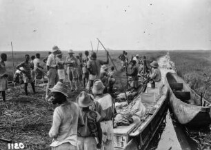 An einem Gewässer : Expeditionsteilnehmer an einem Gewässer mit Kanus
