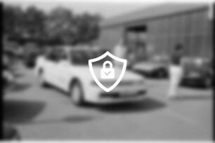 Autohaus Gebrüder Kemnitz GmbH: Heinrich-Hertz-Straße: Außenansicht Firmenhalle: davor auf Parkplatz Pkws, Personen