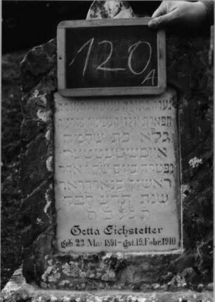 Grabstein 120 (Index: 100090307) Material: Kalkstein, weiße Marmorplatte Zustand: gut Maße HxBxT: 120x45x26 cm Beschreibung: konische Stele/Sockel rustica, Segmentbogenabschl. mit Mittelakroter, Schriftplatte Symbolik: Blatt als Akroter: Grabstein 120A