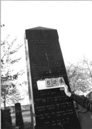 Grabstein 52 (Index: 100116172) Material: Granit, poliert Zustand: gut Maße HxBxT: 255x66x40 cm Beschreibung: dreifach aufgesockelte, obeliskenartige Stele, Schriftfelder auf Stele und mittlerem Sockel: Grabstein 52A (Nachholaufnahme)