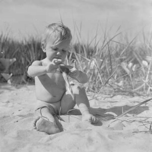 Kleinkind sitzt am Strand