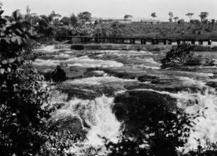 Stromschnellen : Ein Fluss mit Stromschnellen. Im Hintergrund eine Brücke.