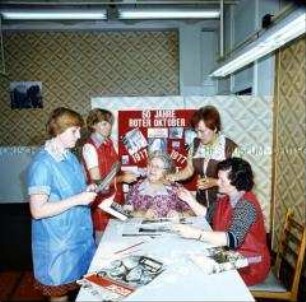 Arbeiterinnen des VEB Robotron Secura Werke Berlin (Ost) und Mitglieder der DSF fertigen eine Wandzeitung zum Jubiläum der Oktoberrevolution