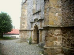 Langhaus Giebelseite West von Südwesten mit Portal sowie Strebepfeilern in Übersicht