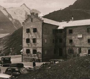 Österreich. Großglockner-Hochalpenstraße. Glocknerhaus der Sektion Klagenfurt (2132 m ü. A.). Davor parkende PKW. Im Hintergrund der Großglockner