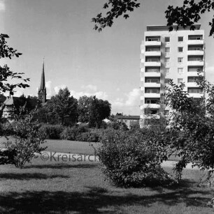 Kurpark: vorn Grünflächen mit Büschen: hinten rechts an Kurparkallee Hochhaus "Liebe": hinten links Turm der Peter-Paul-Kirche