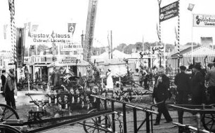 Landmaschinenauststellung auf der Reichsnährstandausstellung 1939 : Ausstellung von Landmaschinen und diverse Stände auf dem Gelände der 5. Reichsnährstand-Ausstellung 1939 in Leipzig. Im Vordergrund Besucher.